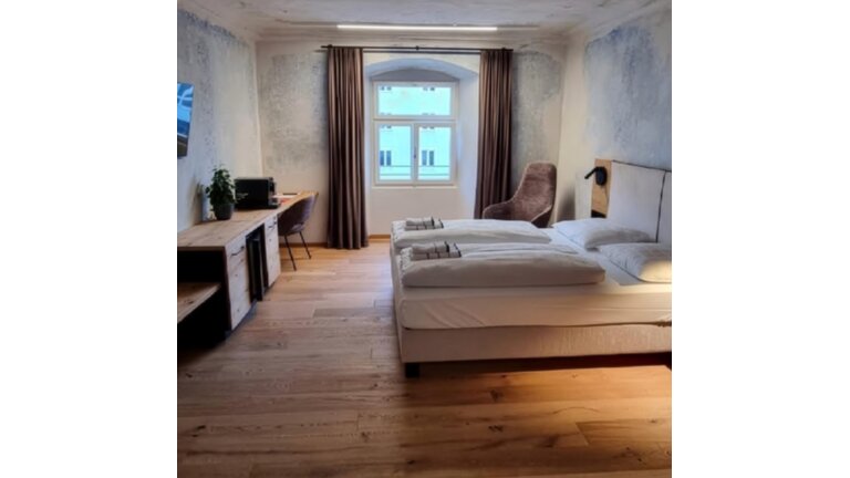 Gemütliches Hotelzimmer mit Doppelbett und Holzfußboden.